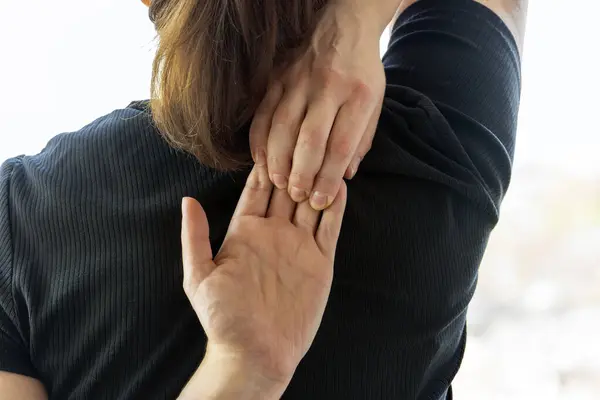 Yoga seansı sırasında omuzlarını arkadan geren bir kadının yakın çekimi. Ellerini arkaya kilitle.