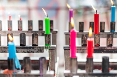 Bunch of prayers candle flames glowing in the Buddhist temple. Symbol of the spiritual atmosphere.