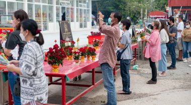 Samut Songkhram Thailand, 29 NOV 2022:  Many people  pray for buddhist and standing at the in front of the  pot of incense in the temple of thailand, pray for good luck and prosperous in their life.