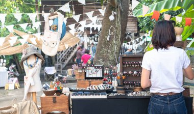 Phrae - Thailand 29 DEC 2022: The back view of a Female Salesperson arranging Jewelry on the table that preparing to sell to Customers at the local market in Thailand.