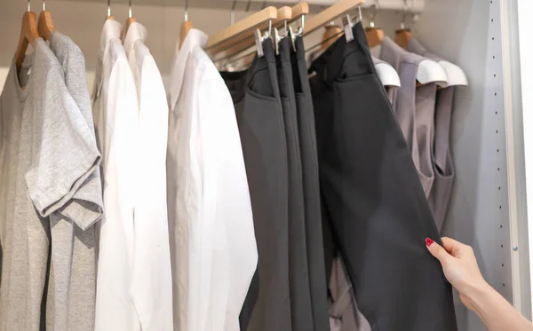 Kvinnlig Hand Väljer Kläder Till Incheckad Mönsterbyxa Hyllan Tygbutiken Varuhus — Stockfoto