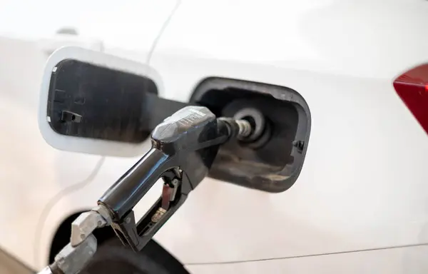 The nozzle fuel fill oil into car tank at pump gas station, For the concept transportation power business technology concept