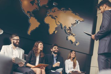 Modern bir ofis binasında iş görüşmesi bekleyen işadamları, İK temsilcisi tarafından yapılacak görüşmeye davet edilen bir sonraki aday.