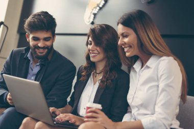 İşadamları işle ilgili konuları tartışıyor ve modern bir ofis binasında çalışıyorlar. Dizüstü bilgisayarda yazan kadınlara odaklan.