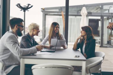 Modern bir ofis binasında birlikte çalışan iş adamları. Ortadaki kadına odaklan.