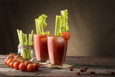 Votka, limon ve domates suyu, acı sos ve kereviz yapraklarıyla süslenmiş buz küpleriyle Bloody Mary kokteyli.