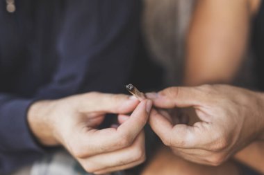 Kanepede oturan iki adamın ayrıntıları. Esrar içip, esrar içiyorlar.