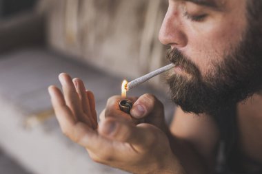 Ot içerken esrar yakan ve rahatlatan genç bir adam