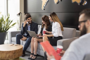 İşadamları işle ilgili konuları tartışıyor ve modern bir ofis binasında çalışıyorlar.