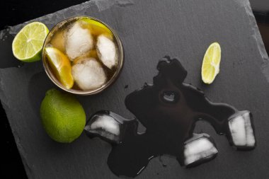 Bir bardak Küba Libre kokteyli, rom, kola, limon ve limon dilimleri ve biraz buz. Cama odaklan.