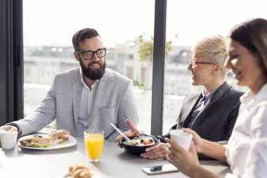 Bir grup iş adamı şirketin restoranında kahvaltı yapıyor. Adama odaklan.