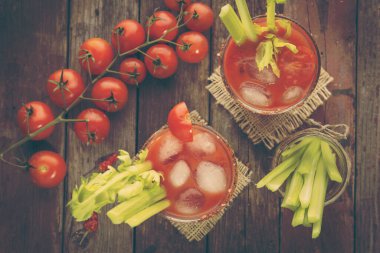 Votka, limon ve domates suyu, acı sos ve kereviz yapraklarıyla süslenmiş buz küpleriyle dolu bir Bloody Mary kokteyli. Gözlüklere odaklan.