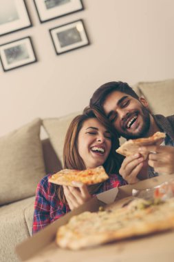 Aşık bir çift pizza yiyor ve eğleniyor.