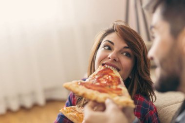 Aşık bir çift öğle yemeğinde pizza yer ve eğlenir.