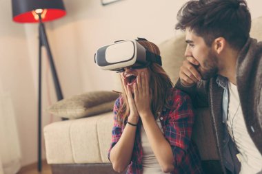 Aşık çift sanal gerçeklik videosu izlerken eğleniyor.