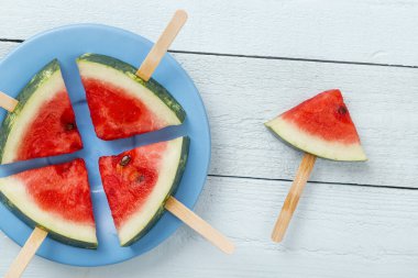 Kırsal açık mavi ahşap masada bir tabakta karpuz şekerlemesi.