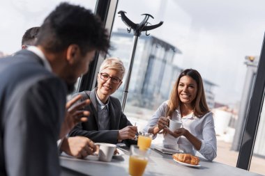 Bir grup iş adamı şirketin restoranında öğle yemeği molasında.