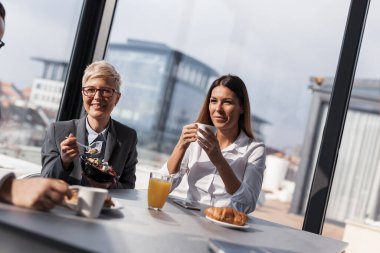 Şirketin restoranında kahve molası veren bir grup iş adamı.