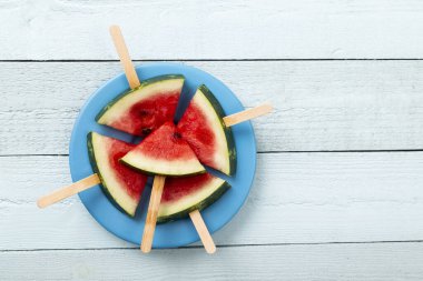Kırsal açık mavi ahşap masada bir tabakta karpuz şekerlemesi.