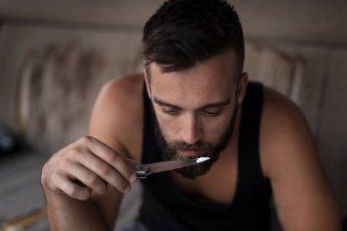 Uyuşturucu satıcısı eroin saflığını test ediyor ve kaçakçılık için mal hazırlıyor.