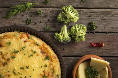 Köy tahtasında servis edilen taze vejetaryen turtasının en iyi resmi. Pastaya ve çiğ brokoliye odaklan.