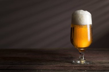 Kırsal ahşap bir masaya yerleştirilmiş soğuk soluk bir bira.