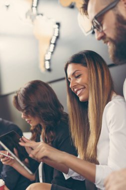 Kahve molasında olan iş adamları modern bir ofis binasında oturuyorlar.