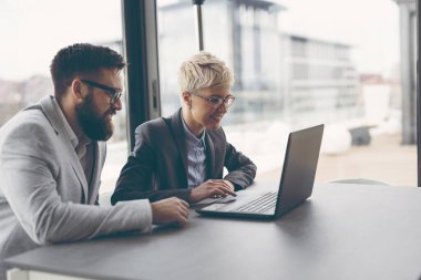 İşadamları işle ilgili konuları tartışıyor, dizüstü bilgisayarda çalışıyorlar. Kadına odaklan.