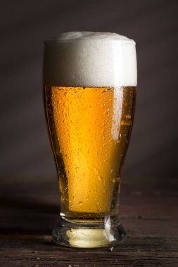 Kırsal ahşap bir masaya yerleştirilmiş soğuk soluk bir bira.