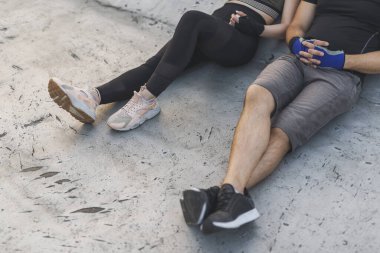 Binanın çatısındaki terasta oturan çift, sıkı bir antrenmana ara veriyor. 