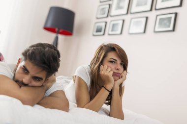 Genç bir çift yatakta uzanıyor, tartışıyor. Kıza odaklan.