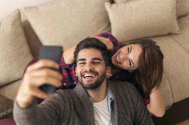 Birbirine aşık çiftler evde boş zamanlarının tadını çıkarırlar, surat asarlar ve selfie çekerler. Adama odaklan.