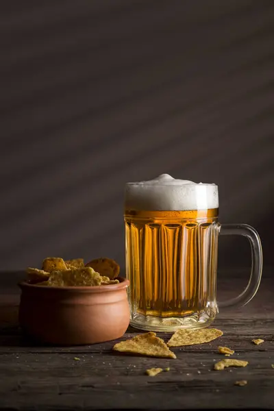 冷たい淡いビールと素朴な木製テーブルのトルティーヤチップのボウル — ストック写真