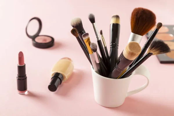 各种粉红背景化妆产品的高角视图 在粉红的底色上涂上刷子 液面粉 口红和眼色 — 图库照片