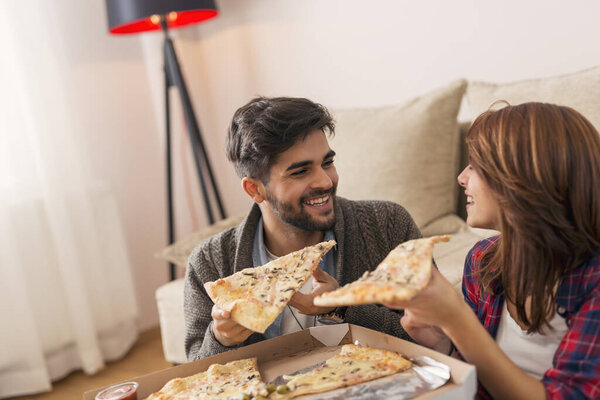 Couple in love eating pizza for lunch and having fun