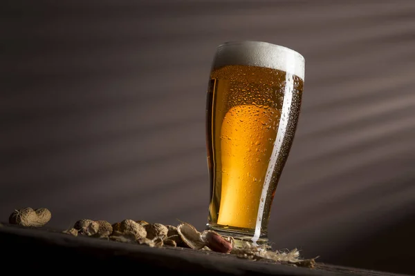 Copo Cerveja Fria Pálida Colocado Uma Montanha Russa Alguns Amendoins — Fotografia de Stock