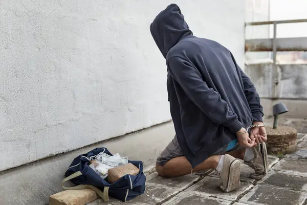 Drug Trafficker Arrest Confined Handcuffs Kneeling Floor Focus Confiscated Goods — Stock Photo, Image