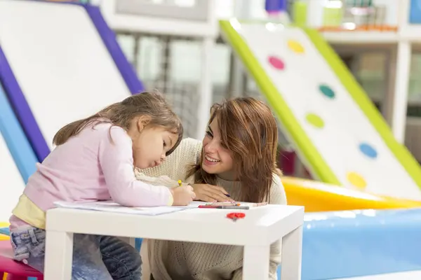 母亲和女儿坐在游戏室的地板上 用彩笔画画和着色 把重点放在母亲身上 — 图库照片