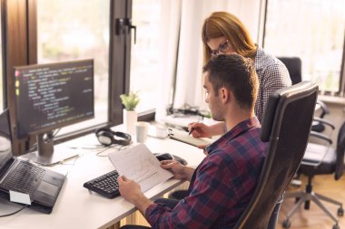 Yazılım geliştirme şirketinde yeni bir proje üzerinde çalışan iki yazılım geliştiricisi. Adama odaklan.