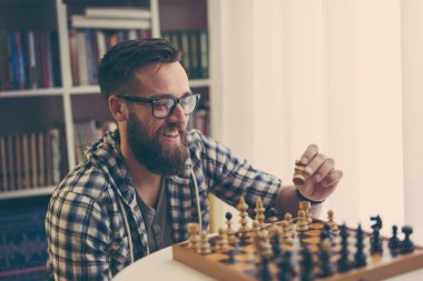 Adam evde satranç oynuyor, boş zamanlarının tadını çıkarıyor.