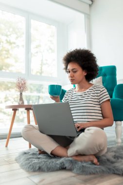 Kadın covid-19 salgını sırasında evden işe gidip geliyor, dizüstü bilgisayarda çalışıyor ve kahve içiyor, kadın uzaktan evden çalışıyor.