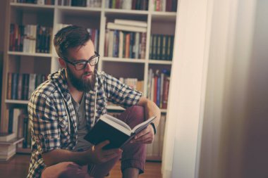 Genç adam kitap okurken boş zamanlarının tadını çıkarıyor.