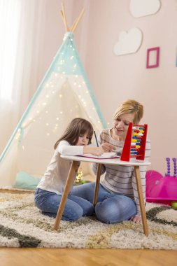 Anne ve kızı, abaküs ile matematik öğreniyor, özet çıkarıyor ve çıkartıyor.