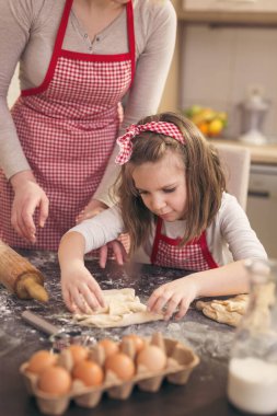 Anne ve kızı mutfakta eğleniyor, birlikte vakit geçiriyor ve rulo yapıyorlar.