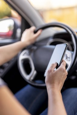 Direksiyon tutan ve akıllı bir telefona mesaj yazan kadın ellerinin ayrıntıları.