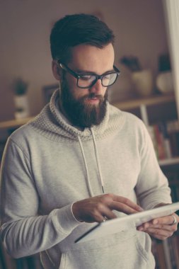 Ev ofisinde çalışan yakışıklı genç bir girişimci.