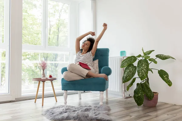 Beautiful Young Mixed Race Woman Stretching While Sitting Armchair Window — Stock Photo, Image