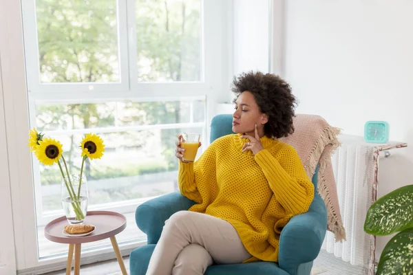 漂亮的混血女子在家里休息 坐在扶手椅上 早餐喝橙汁 — 图库照片