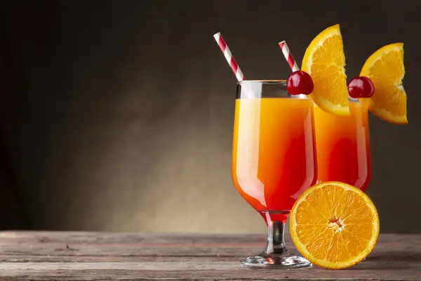 オレンジとマラスチーノチェリーのスライスで装飾されたテキーラサンライズカクテル ザクロジュースとオレンジジュース — ストック写真