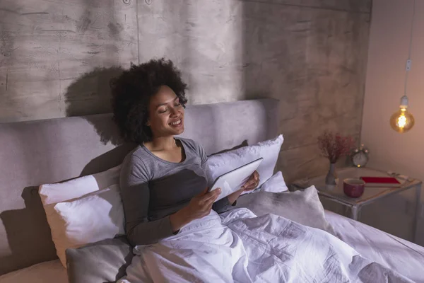 레이스 잠옷을 아침에 침대에 태블릿 컴퓨터를 영화를 재미와 집에서 — 스톡 사진